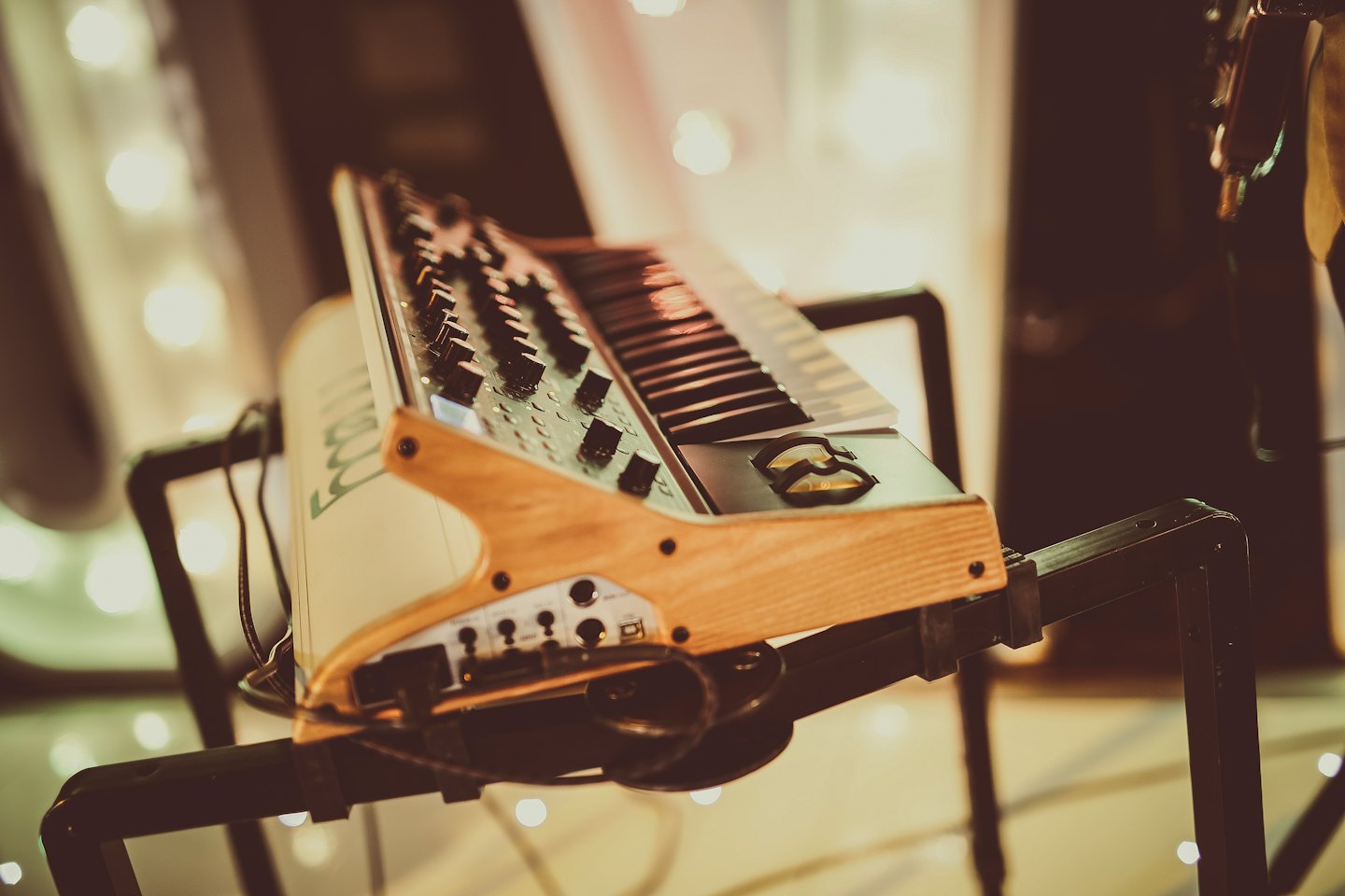 Vintage-Synthesizer mit Tastatur und Reglern auf einem Ständer.